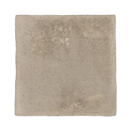 Vierkante terracotta tegel met een ruw, gestructureerd oppervlak en gedempte beige tint, geïsoleerd op een witte achtergrond.