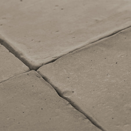 Terracotta tiles are closely arranged, forming a textured, grid-like surface, creating a rustic floor setting.