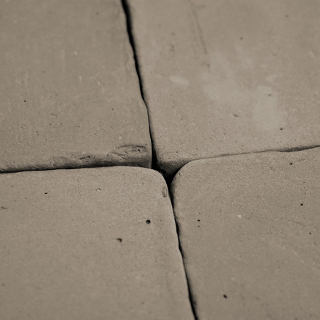 Four terracotta tiles, placed closely, form a square pattern. surface displays uneven, rustic texture and subtle imperfections.