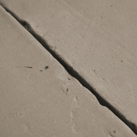 Terracottategels liggen ongelijkmatig geplaatst, waardoor zichtbare scheuren en een enigszins ruwe textuur zichtbaar zijn in een