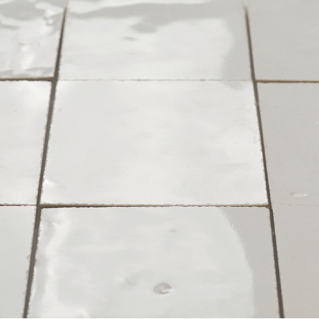 Glanzende terracottategels zijn naadloos gerangschikt, met kleine onvolkomenheden, en reflecteren het licht in een zacht verlich Glanzende terracottategels zijn naadloos gerangschikt, met kleine onvolkomenheden, en reflecteren het licht in een zacht verlich