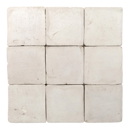 Neuf carreaux carrés en terre cuite sont disposés selon une grille 3x3, affichant une texture de surface rugueuse et blanc cassé