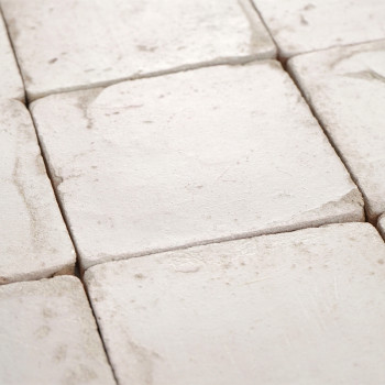 Los azulejos cuadrados de terracota descansan en un elegante patrón de cuadrícula, mostrando una textura suave y desgastada bajo
