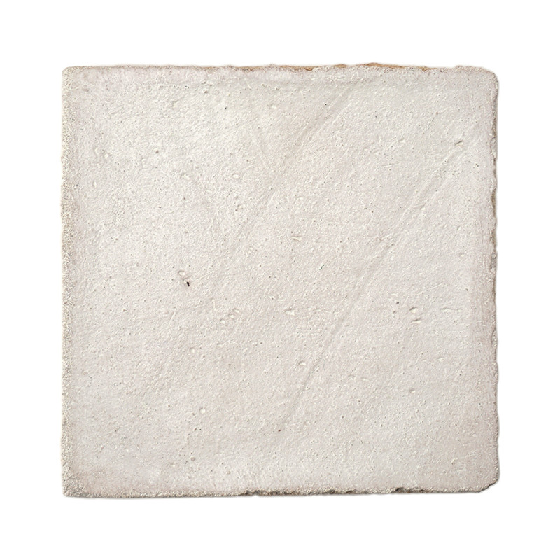 Les carreaux carrés en terre cuite semblent texturés, reposant sur un fond blanc uni, mettant en valeur sa surface rugueuse et i