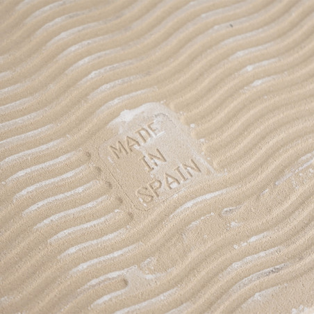 Un carreau de couleur sable présente des vagues en relief, créant une apparence texturée. Au centre, le texte « MADE IN SPAIN » 