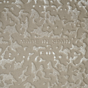 Op de keramische tegels in reliëf staat de tekst `MADE IN SPAIN.` Met een gestructureerd, golvend oppervlak in een neutrale beig