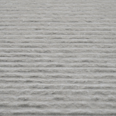 La superficie del azulejo gris muestra ranuras horizontales uniformes, creando un patrón texturizado en su totalidad, sugiriendo