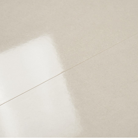 Eine glänzende beige Fliese reflektiert das Licht dezent und lässt eine glatte, ebene Oberfläche entstehen. Der Kontext deutet a