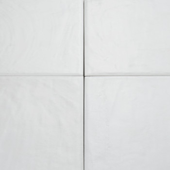 Four light grey square tiles, aligned in a grid formation, display subtle textures and grooves, creating a minimalistic, clean s