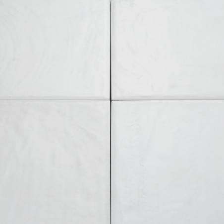 Four light grey square tiles, aligned in a grid formation, display subtle textures and grooves, creating a minimalistic, clean s