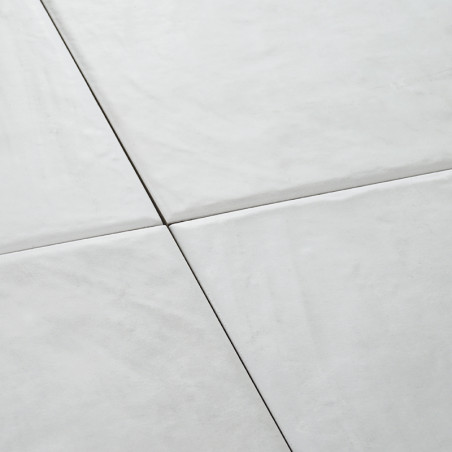 Four white ceramic tiles form a seamless square pattern, creating a smooth, clean surface in a minimalistic and modern setting.