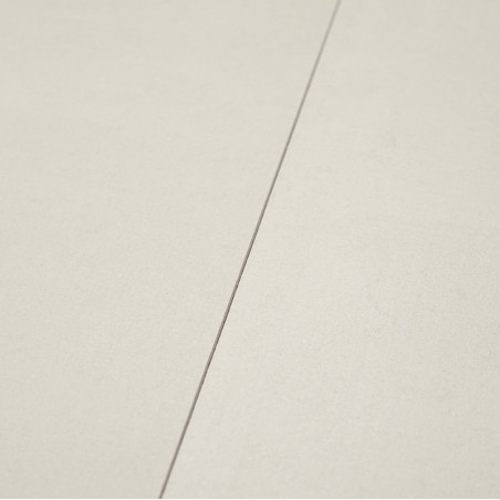 Un carreau de céramique lisse et beige repose à plat, coupé par une étroite ligne de coulis, créant une surface minimaliste et é