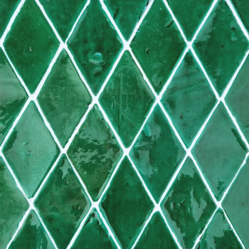Green diamond-shaped terracotta tiles arranged in a repeating pattern, reflective glaze catching light, creating a vibrant, unif