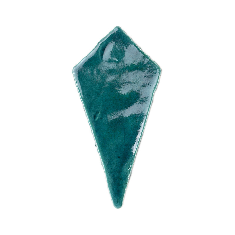 Een glanzende, blauwgroen, vliegervormige terracottategel ligt plat tegen een effen witte achtergrond.