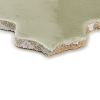 Ladrilhos de terracota de cor creme formam um padrão floral, com superfícies brilhantes refletindo a luz em um arranjo sobrepost