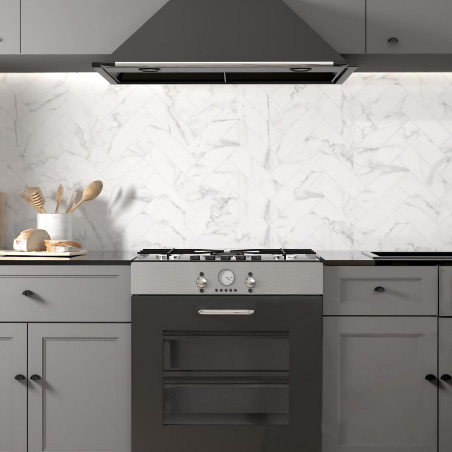 Uma cozinha moderna possui um fogão preto com exaustor metálico. Armários cinza cercam o fogão, contra um backsplash de azulejos