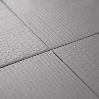 Cuatro mosaicos cuadrados con un patrón de cuadrícula texturizado están perfectamente alineados en una vista de primer plano, en