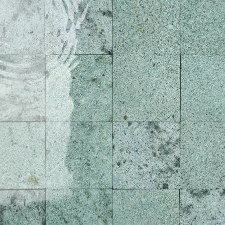 Les carreaux de pierre affichent un subtil motif moucheté, partiellement immergé, avec de légères ondulations d’eau sur leur sur