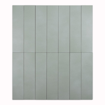 Un long carreau rectangulaire vert clair se dresse sur un fond blanc uni, mettant en valeur sa texture de surface lisse et mate.