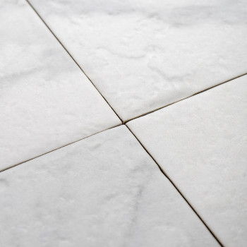 Les carreaux de marbre blanc forment un motif homogène, se croisant proprement au niveau des lignes diagonales. la texture est l