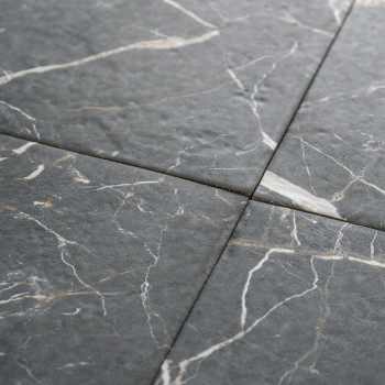 Quatre carreaux de pierre gris foncé se croisent, formant un motif en croix. Des veines blanches et gris clair traversent la sur