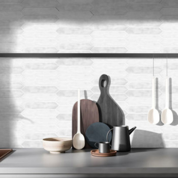 Artículos de cocina variados, como tablas de cortar, tazones, una tetera y cucharones colgantes, dispuestos sobre una encimera c