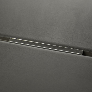 A dark gray tile with a metallic bar inset across its surface, reflecting light, set against a smooth, minimalistic background.