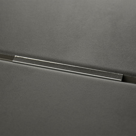 A dark gray tile with a metallic bar inset across its surface, reflecting light, set against a smooth, minimalistic background.