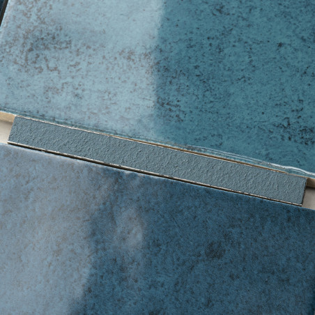 Les carreaux de céramique aux surfaces texturées et dégradées de bleu sont superposés et disposés, mettant en valeur les nuances Les carreaux de céramique aux surfaces texturées et dégradées de bleu sont superposés et disposés, mettant en valeur les nuances