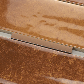 Le carreau rectangulaire marron présente une finition brillante avec de subtiles variations de texture, entourées de fines bordu