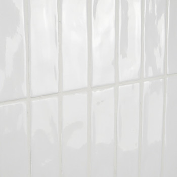 Les carreaux rectangulaires blancs brillants reflètent la lumière, donnant une impression de propreté et de simplicité dans un a