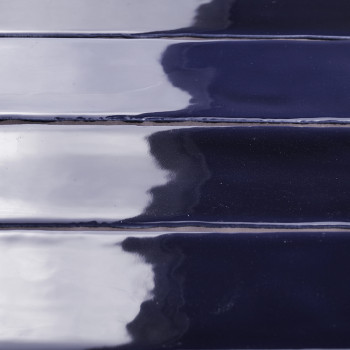 Los azulejos brillantes de color azul marino, alineados horizontalmente, reflejan la luz y las sombras en su superficie formando