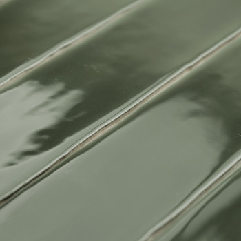 Carreau de céramique vert brillant présentant un motif nervuré en relief aux reflets subtils. Le carreau est posé à plat, présen