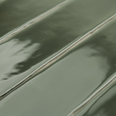 Glänzende grüne Keramikfliese mit erhabenem, geripptem Muster und dezenten Reflexen. Die Fliese wird flach verlegt und zeigt ein Glänzende grüne Keramikfliese mit erhabenem, geripptem Muster und dezenten Reflexen. Die Fliese wird flach verlegt und zeigt ein