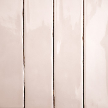 Vier rechthoekige, glanzende beige tegels, verticaal uitgelijnd met dunne, donkere voeglijnen, scheiden ze, waardoor een strak e