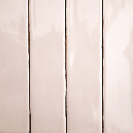 Vier rechthoekige, glanzende beige tegels, verticaal uitgelijnd met dunne, donkere voeglijnen, scheiden ze, waardoor een strak e