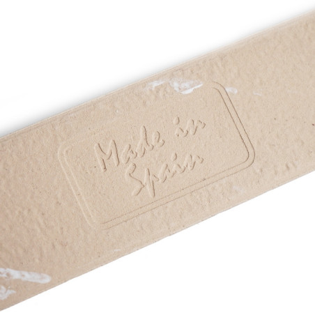Um ladrilho retangular marrom claro exibe o texto em relevo que diz `Made in Spain.` A superfície do ladrilho parece texturizada