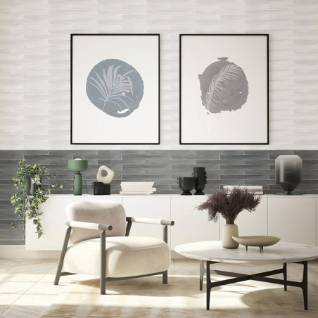 Un salon moderne comprend une chaise crème face à une table basse ronde avec des plantes séchées, sur fond d'art mural abstrait 