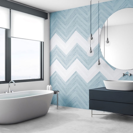 El baño cuenta con una bañera independiente y un tocador moderno colocado contra una pared de azulejos de chevrón azules y blanc