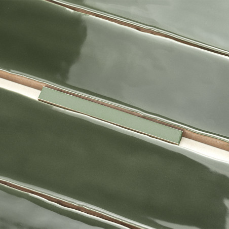 Les carreaux de céramique verts brillants et allongés sont empilés avec un léger chevauchement, présentant des surfaces lisses e
