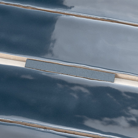 Glänzende, dunkelblaue Keramikfliesen mit abgeschrägten Kanten sind sauber ausgerichtet. Fugenlinien trennen die Fliesen, reflek