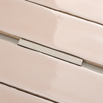 Les carreaux beiges rectangulaires brillants sont alignés avec des espaces étroits, créant une surface élégante. Une petite entr