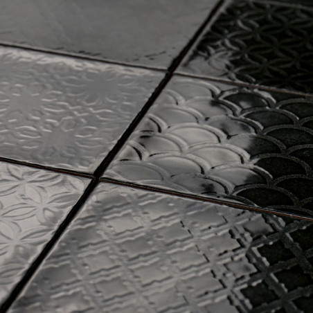 Les carreaux de céramique brillants affichent des motifs géométriques, notamment des cercles et des croix, créant une surface te