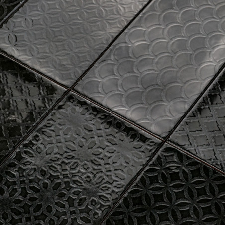 Os ladrilhos de cerâmica preta apresentam intrincados padrões geométricos em relevo, incluindo arcos sobrepostos e círculos entr Os ladrilhos de cerâmica preta apresentam intrincados padrões geométricos em relevo, incluindo arcos sobrepostos e círculos entr