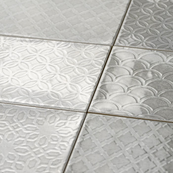 Les carreaux carrés aux motifs géométriques en relief s'emboîtent parfaitement, mettant en valeur des motifs circulaires qui se 