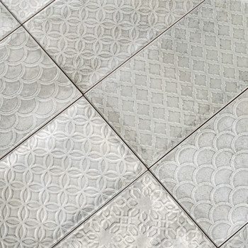 El patrón de mosaico presenta seis rectángulos, cada uno de ellos grabado con diseños geométricos como círculos y diamantes, cre