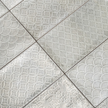 Das Fliesenmuster besteht aus sechs Rechtecken, in die jeweils geometrische Muster wie Kreise und Rauten eingeprägt sind, wodurc