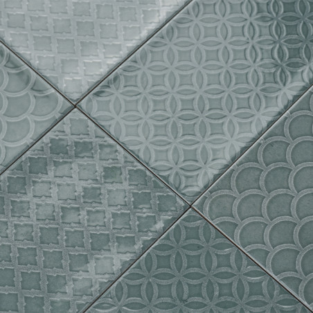 Una colección de azulejos verdes muestra patrones geométricos, que incluyen círculos, diamantes y vieiras, creando una superfici Una colección de azulejos verdes muestra patrones geométricos, que incluyen círculos, diamantes y vieiras, creando una superfici