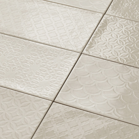 Les carreaux de céramique présentent divers motifs géométriques en relief, posés à plat et parfaitement imbriqués, créant une su