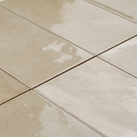 Los azulejos cerámicos rectangulares, colocadas en forma de cuadrícula, exhiben una mezcla alterna de superficies beige mate y b